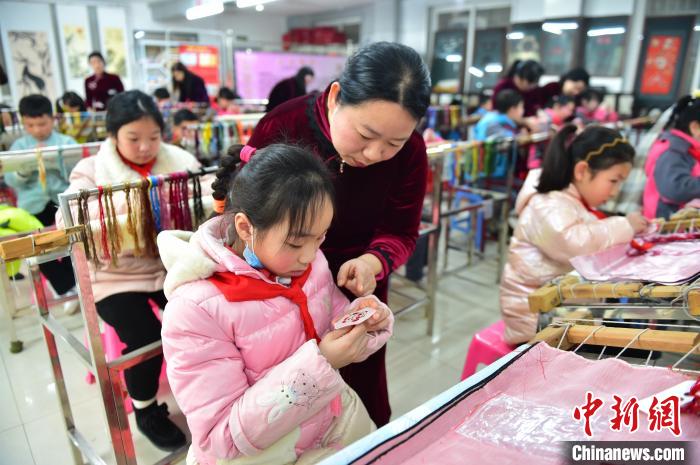 江西省級非遺豫章繡傳承人手把手指導小學生繡制2022年北京冬奧會吉祥物“冰墩墩”形象?！∮髟屏?攝