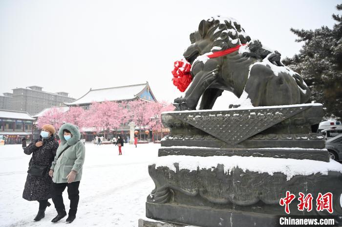 2月13日，民眾在呼和浩特市大召?gòu)V場(chǎng)雪中漫步?！⑽娜A 攝