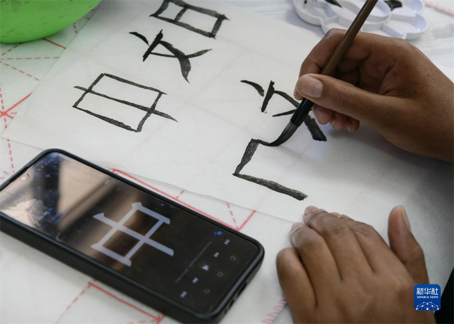 4月18日，肯尼亞學生在內羅畢大學孔子學院舉辦的活動上寫毛筆字。肯尼亞內羅畢大學孔子學院18日舉辦“中文，增進文明對話”主題活動，慶祝即將到來的第14個聯(lián)合國中文日。肯尼亞學生參與互動，進行書法、剪紙、唱中文歌等活動。新華社記者 韓旭 攝