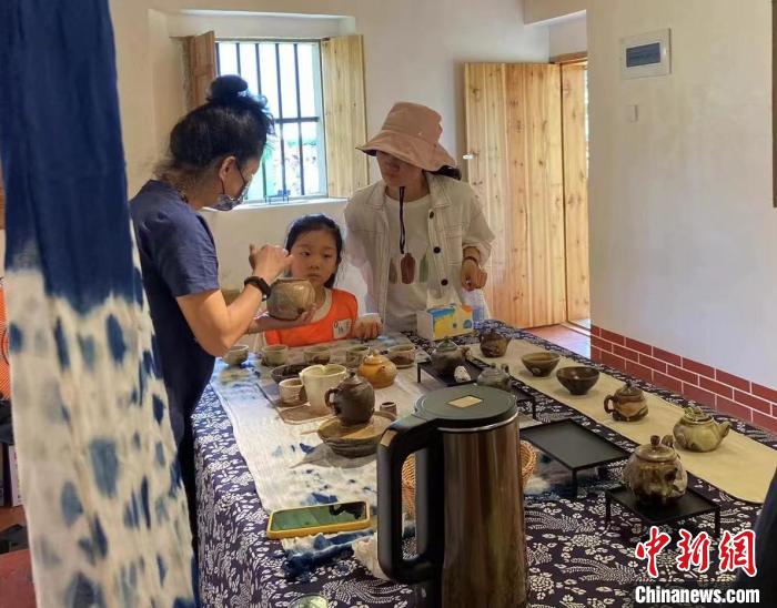 圖為：游客正在咨詢臺灣柴燒作品?！∪~秋云 攝