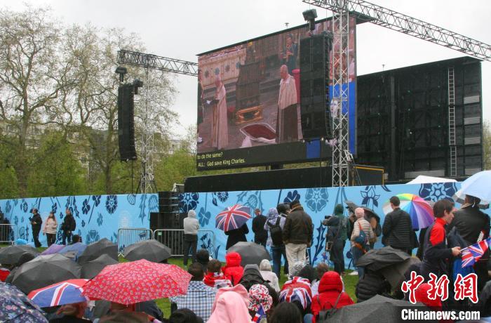 當?shù)貢r間5月6日，英國國王查爾斯三世的加冕儀式舉行。民眾雨中觀看儀式。　歐陽開宇 攝