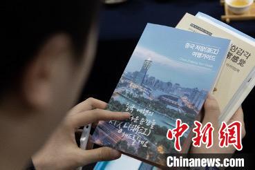 參展觀眾閱讀浙江文旅手冊(cè)?！《≌裾?攝