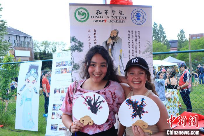 孩子們展示自己的吹墨畫團(tuán)扇作品。　魯汶孔子學(xué)院供圖