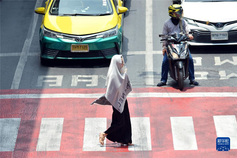5月17日，行人在泰國曼谷街頭用圍巾遮陽。新華社發(fā)（拉亨攝）