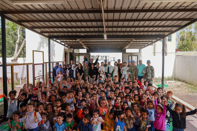 當(dāng)?shù)貢r(shí)間5月30日，黎巴嫩南部庫(kù)雷拉公立小學(xué)，“六一”國(guó)際兒童節(jié)前夕，中國(guó)第21批赴黎維和多功能工兵分隊(duì)官兵看望慰問(wèn)學(xué)校師生，并開(kāi)展文化交流活動(dòng)，圖為我維和官兵同師生合影。李竹林?jǐn)z