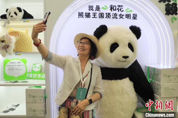 美國華視總裁楊蓮花與大熊貓文創(chuàng)產(chǎn)品合影。　王磊 攝