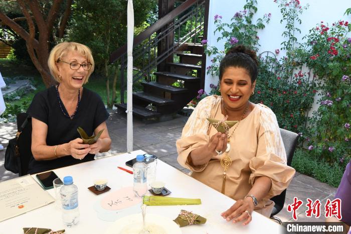 圖為嘉賓展示包粽子成果?！“亓种袊幕行墓﹫D。