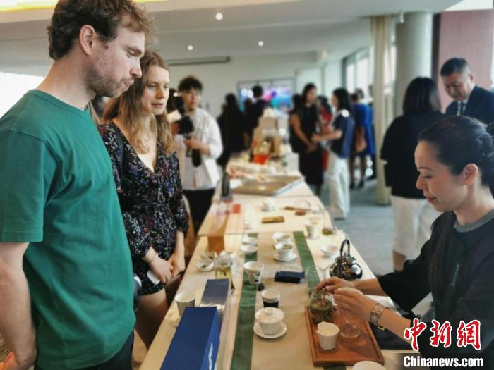 現(xiàn)場(chǎng)觀眾觀看中國(guó)展臺(tái)茶藝表演、了解茶文化。　靖樹(shù) 攝