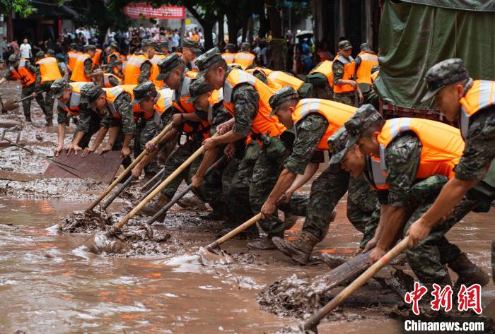 7月4日，萬(wàn)州區(qū)五橋街道，武警官兵清理街道上的淤泥?！∪矫宪?攝