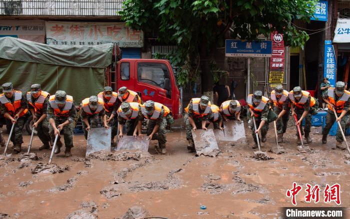 7月4日，萬(wàn)州區(qū)五橋街道，武警官兵清理街道上的淤泥?！∪矫宪?攝