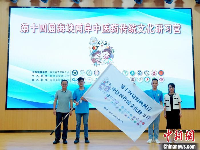 共青團(tuán)福建省委副書記吳雪(右一)、福建中醫(yī)藥大學(xué)黨委副書記林羽(左一)為兩岸學(xué)生代表頒授營(yíng)旗。　許燁婷 攝