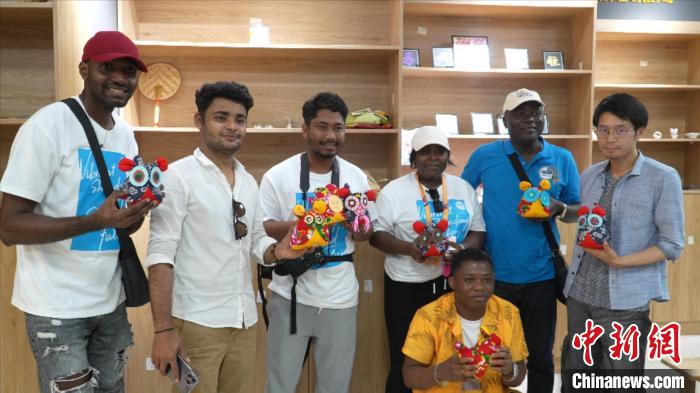 圖為國際青年代表展示親手制作的東營非遺黃河口布偶 ?！↓R魯 攝