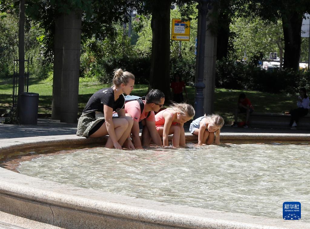 7月8日，人們在德國法蘭克福的一處噴泉玩水。近日，德國法蘭克福逐漸迎來暑熱天氣。新華社記者 張帆 攝