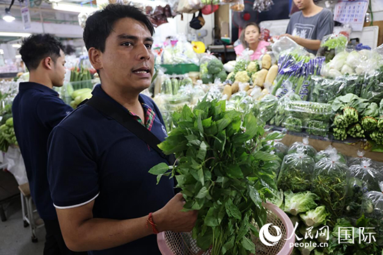 7月19日，泰國曼谷藍象餐廳員工向參加活動的多國代表介紹如何挑選新鮮蔬菜。 人民網(wǎng)記者 張矜若攝
