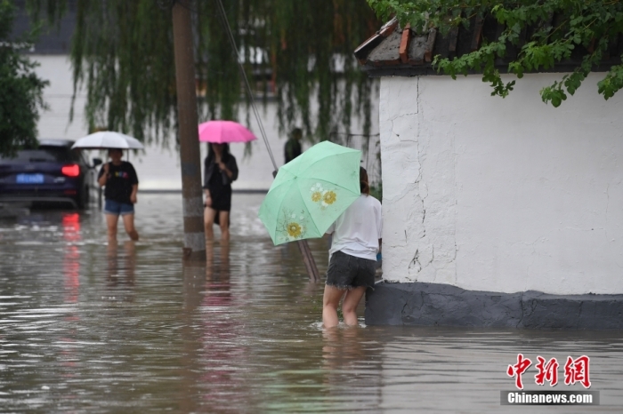 7月31日，市民行走在雨中的北京房山區(qū)瓦窯頭村。北京市氣象臺當日10時發(fā)布分區(qū)域暴雨紅色預警信號。北京市水文總站發(fā)布洪水紅色預警，預計當日12時至14時，房山區(qū)大石河流域?qū)⒊霈F(xiàn)紅色預警標準洪水。<a target='_blank' href='/'><p  align=