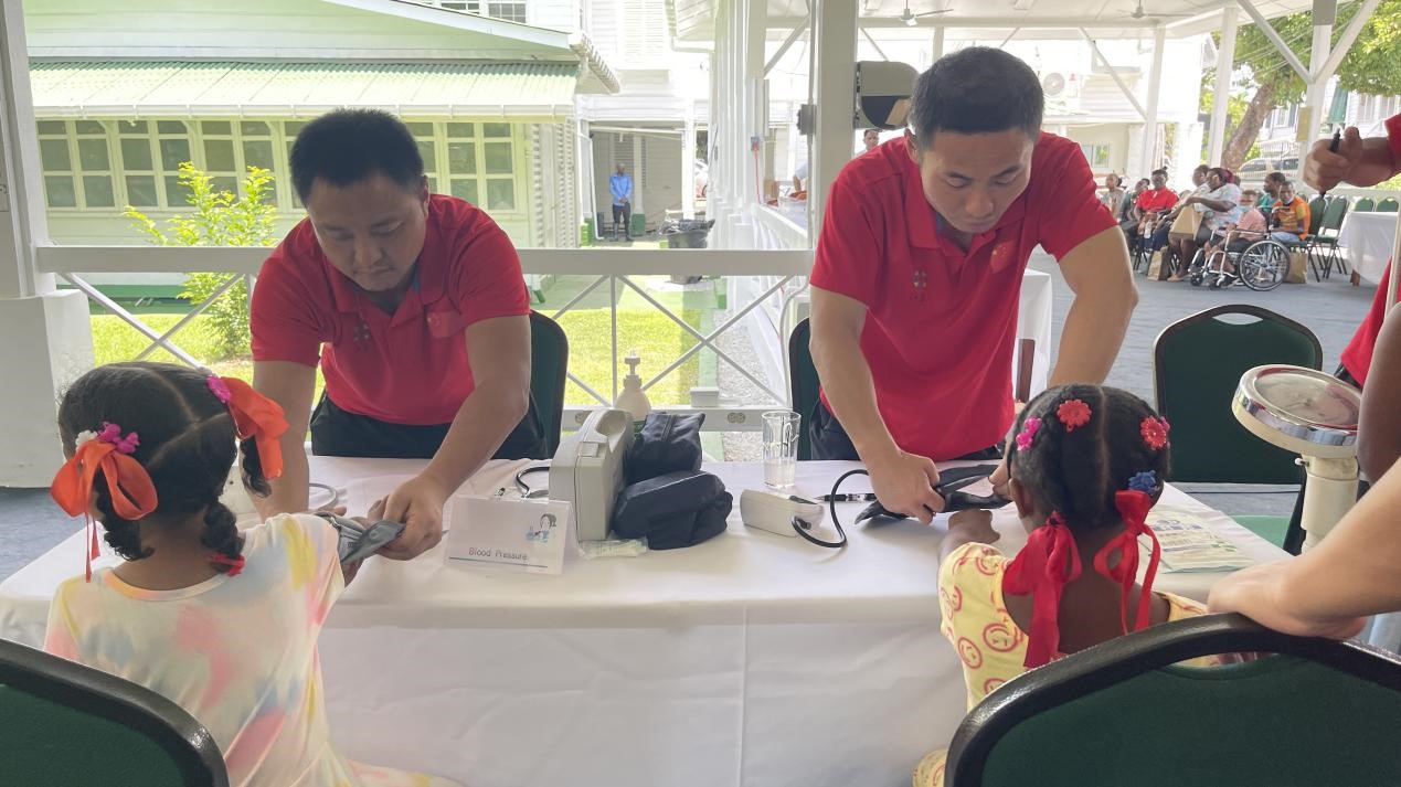 醫(yī)療隊(duì)員為福利院兒童進(jìn)行檢查。第18期援圭亞那醫(yī)療隊(duì)供圖