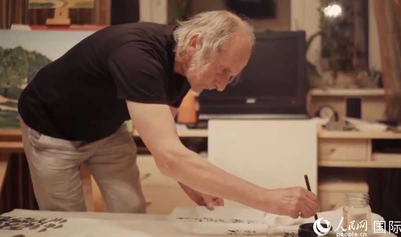 伊戈爾·布爾東諾夫在畫作上題詞。人民網(wǎng)記者 馬天翼攝