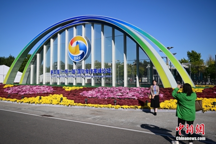 10月15日，北京，工作人員在國家會議中心外的第三屆“一帶一路”國際合作高峰論壇景觀布置前拍照留念。當(dāng)日，位于國家會議中心的第三屆“一帶一路”國際合作高峰論壇新聞中心啟動試運(yùn)行。據(jù)悉，第三屆“一帶一路”國際合作高峰論壇將于10月17日至18日在北京舉行。<a target='_blank' href='/'><p  align=