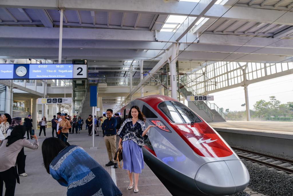 10月17日，在印度尼西亞萬隆德卡魯爾站，乘客在站臺(tái)上和雅萬高鐵高速動(dòng)車組列車合影。