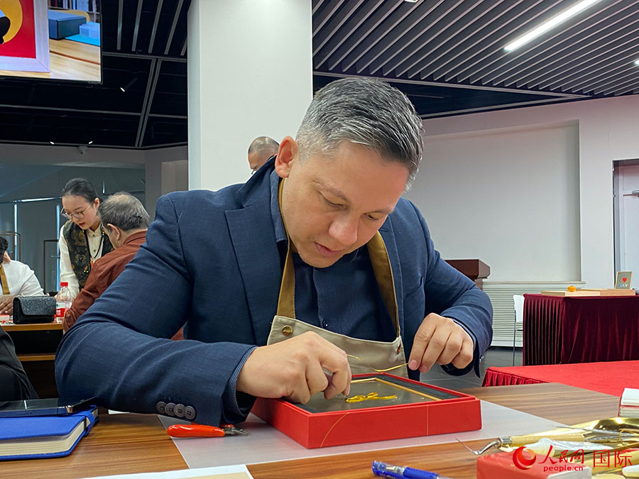 2023“一帶一路”媒體合作論壇聯(lián)合采訪團團員，親身體驗景泰藍工藝。人民網(wǎng)記者 于洋攝