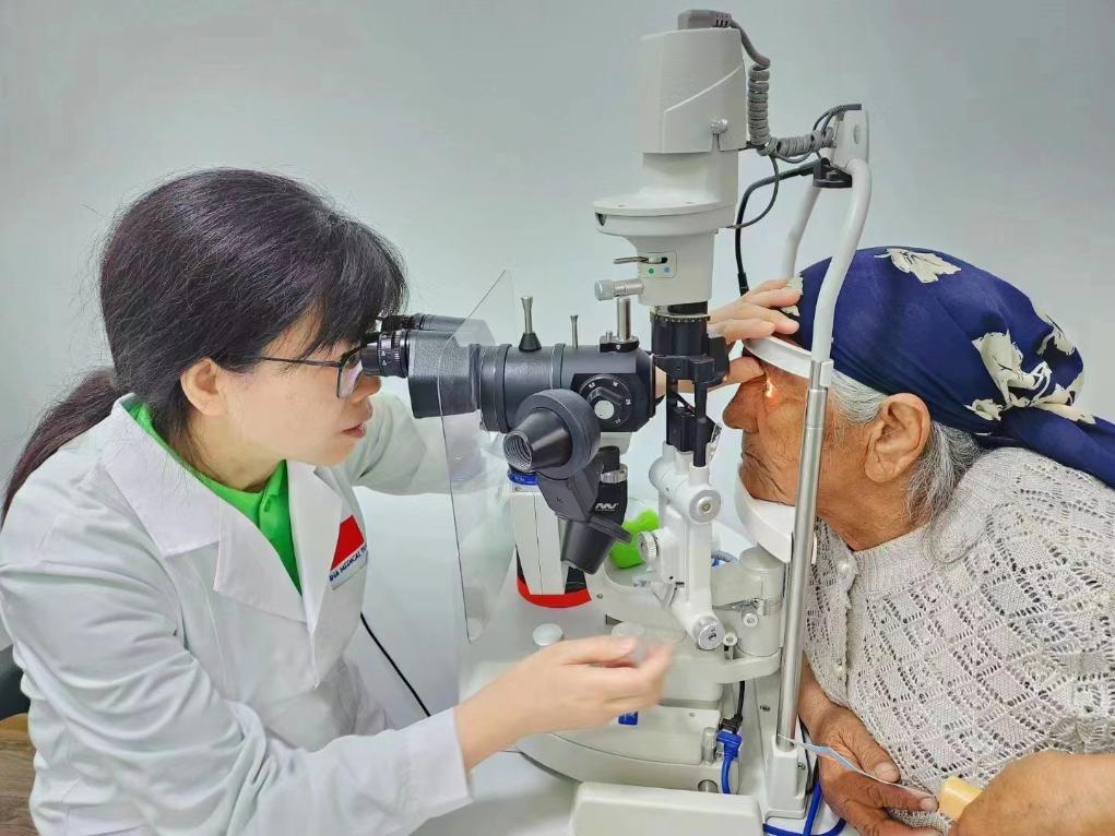 北京大學(xué)人民醫(yī)院眼科醫(yī)生鮑永珍正在為中亞白內(nèi)障患者進(jìn)行眼部檢查。（北京大學(xué)人民醫(yī)院供圖）