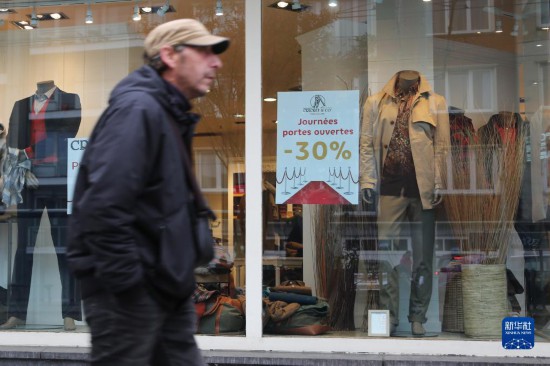   10月31日，一名男子從比利時(shí)布魯塞爾一家貼有打折信息的店鋪前走過(guò)。新華社記者 趙丁喆 攝