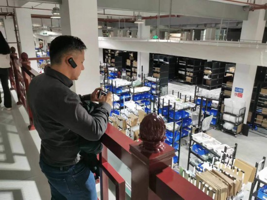 2023“一帶一路”媒體合作論壇聯(lián)合采訪團(tuán)團(tuán)員在仁和醫(yī)藥物流園拍攝記錄轉(zhuǎn)運(yùn)流程。（本報(bào)記者 黃超攝）