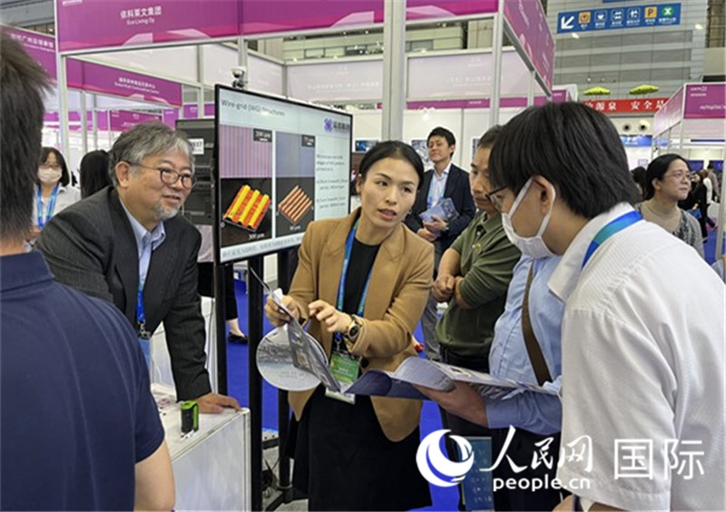 工作人員向參觀者介紹超級(jí)噴墨技術(shù)。（人民網(wǎng)記者 陳思攝）