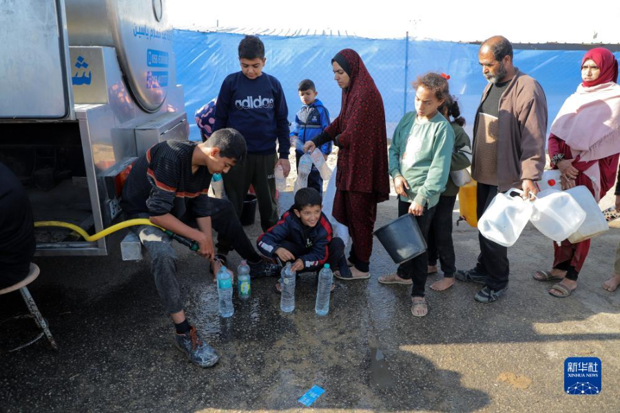 12月8日，在加沙地帶南部城市拉法一處臨時(shí)營地內(nèi)，人們排隊(duì)打水。新華社發(fā)（里澤克·阿卜杜勒賈瓦德 攝）
