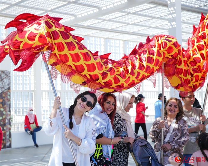 游客體驗舞龍。 人民網(wǎng) 塔里克·易卜拉欣攝