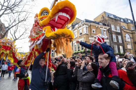 2月11日，人們在英國倫敦的新春巡游活動中觀看舞龍表演。新華社發(fā)（史蒂芬·程攝）