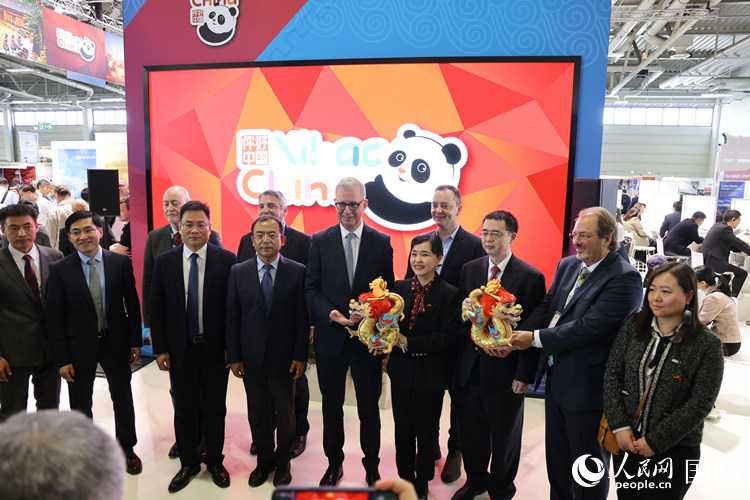 參加中國館開幕式的嘉賓們在“你好 中國” 展臺前合影留念。