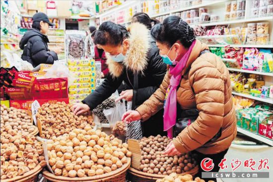 　　在長沙南門口菜市場附近的一家炒貨店內(nèi)，市民正在選購年貨。　　長沙晚報(bào)全媒體記者 范宏歡 攝