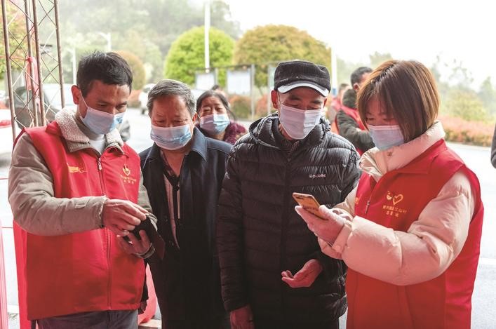 長沙縣黨員志愿者正在幫助參與核酸檢測的群眾掃描“場所碼”。劉思源 攝