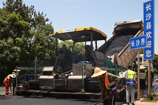 工人正在進(jìn)行“極薄磨耗層”路面的鋪筑。受訪單位供圖
