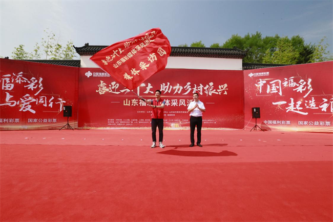 為媒體采風(fēng)團(tuán)授旗。 山東省福彩供圖