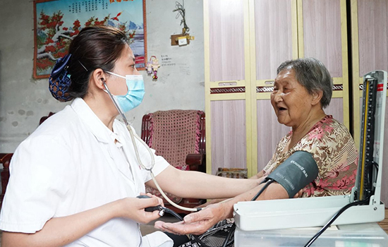 護(hù)理團(tuán)隊(duì)醫(yī)生為老人測量血壓。 陳佳兵攝