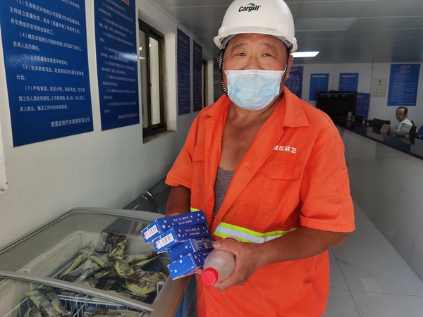 1環(huán)衛(wèi)工倪建宏小憩后，為還同事帶去冷飲。人民網(wǎng)記者王繼亮攝