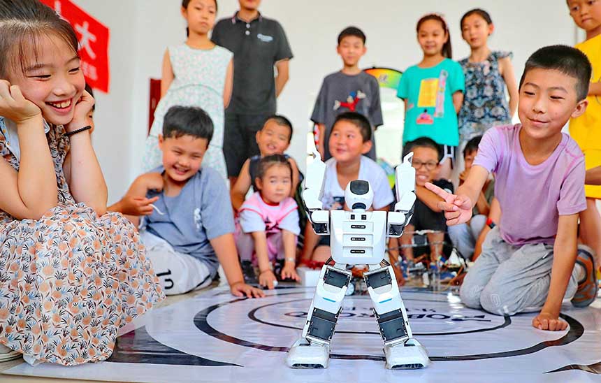 2022年7月19日，河北省秦皇島市海港區(qū)白塔嶺街道秦皇半島第二社區(qū)內(nèi)，小朋友正在觀看“機(jī)器人跳舞”。 曹建雄攝