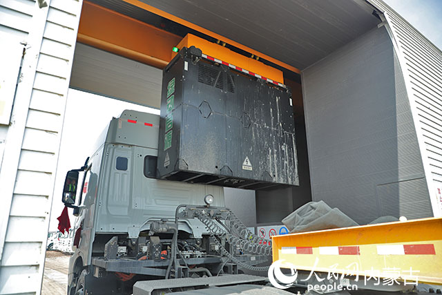 萬利新能源數(shù)字陸港里，正在充換電站進(jìn)行換電的重卡。人民網(wǎng)記者 趙夢月攝