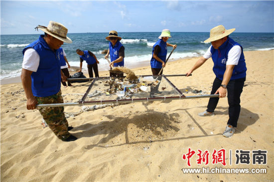 環(huán)保志愿者用篩網(wǎng)“淘”出海灘上的垃圾。