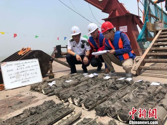 圖為勘察設(shè)計(jì)人員與海事局工作人員查看巖芯情況。　魏震 攝