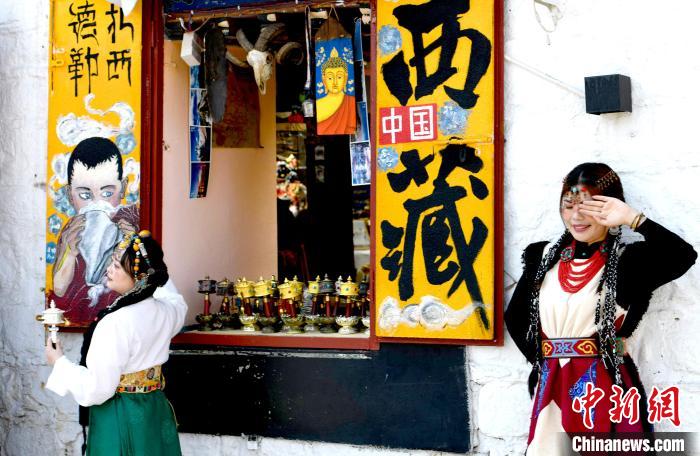 4月17日，游客身著藏式元素服裝在拉薩八廓街拍照留念?！±盍?攝