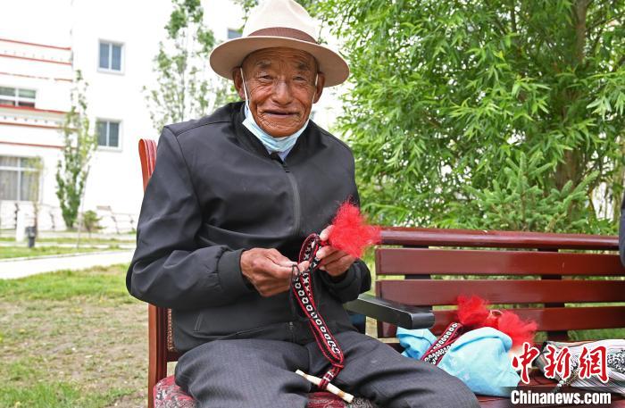 圖為曲松縣特困人員集中供養(yǎng)中心老人在做傳統(tǒng)手工編織?！≮w朗 攝