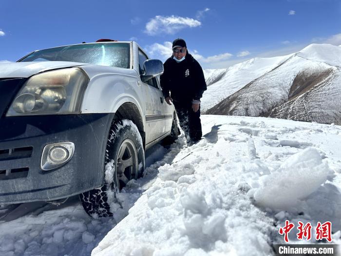 圖為生態(tài)管護人員準備在雪地推車?！《“瓦_杰 攝