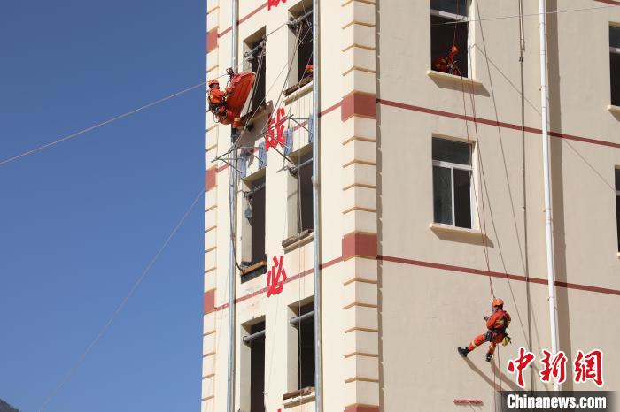 圖為消防指戰(zhàn)員進(jìn)行繩索救援演練。　朱科熹 攝