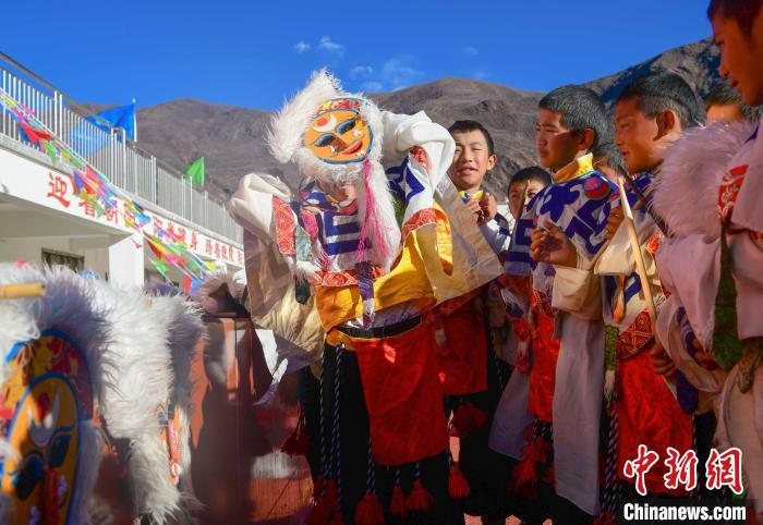 圖為加查縣安繞鎮(zhèn)小學學生在試穿藏戲面具?！∝暩聛硭?攝
