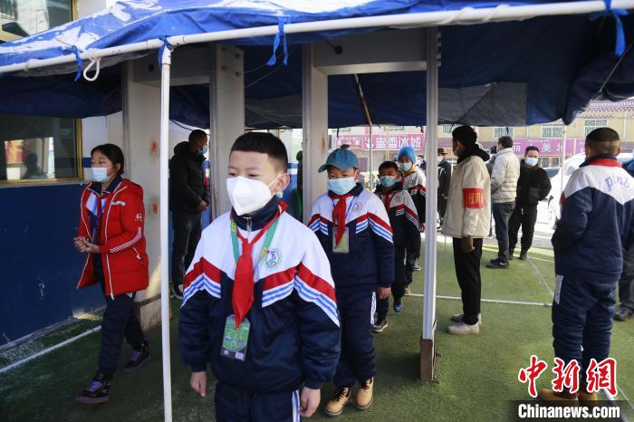 圖為學生測量體溫后進入校園?！●R銘言 攝