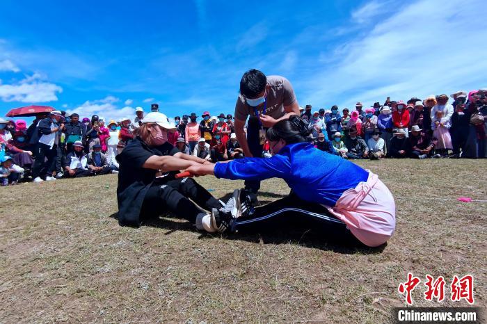 圖為當地民眾進行蹬棍比賽?！±铍h 攝