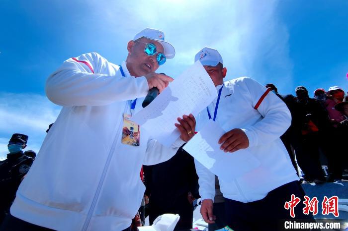 圖為裁判員統(tǒng)計牧民運動項目比賽成績。　李雋 攝